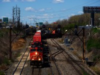 CN 120 is exiting Taschereau Yard with three DC units up front. VIA 65 is lined on the South Track.