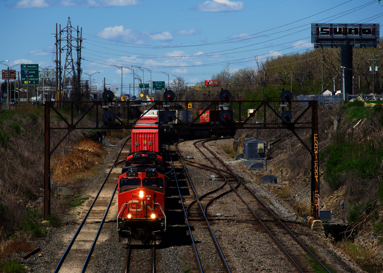 CN 120 is exiting Taschereau Yard with three DC units up front. VIA 65 is lined on the South Track.