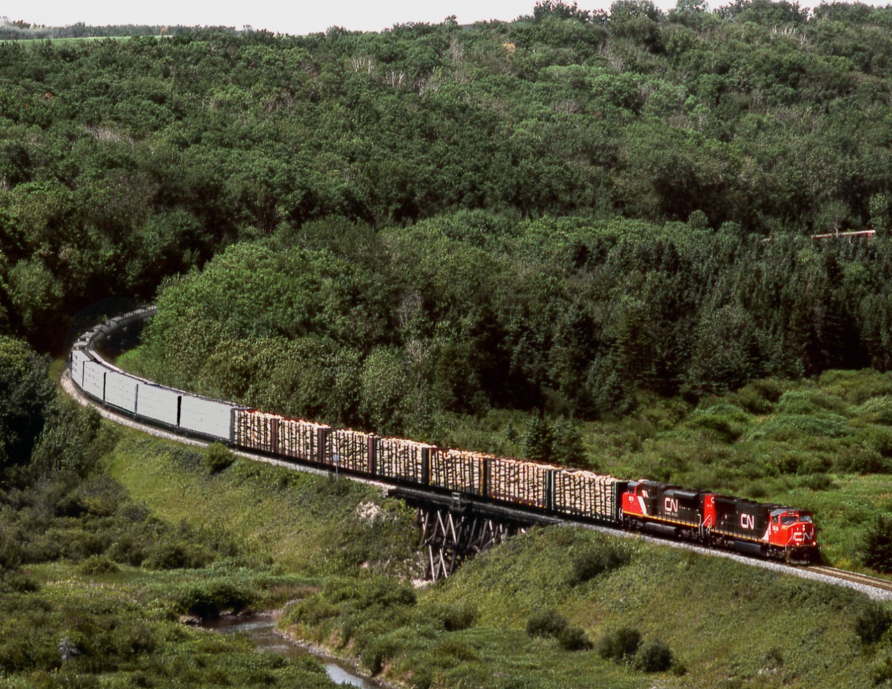 Eastbound train 452 on CN's Prairie North Line has just crossed from Saskatchewan to Manitoba and crosses Boggy Creek, a tributary of The Assiniboine River