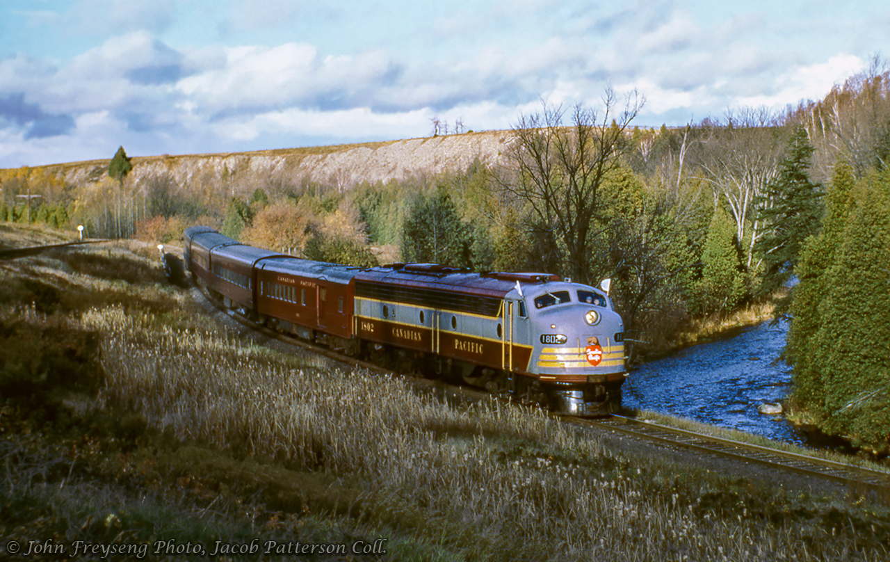 The weekend of October 23 & 24, 1965 saw the Upper Canada Railway Society run an excursion on each of the class one railways.  The Saturday trip running on the Canadian Pacific behind CPR E8A 1802 departed Toronto Union station for Hamilton's TH&B Hunter Street station via the Oakville Sub, before heading up to Guelph Junction, Streetsville, and north to Orangeville before returning to Union Station.  Here, the train makes a runpast at Cataract, just south of the junction with the Elora Sub, seen climbing the grade at left.The Sunday excursion on the Canadian National ran from Toronto - Georgetown - Beeton - Barrie - Newmarket - Toronto and was captured at Beeton by Doug Page.John Freyseng Photo, Jacob Patterson Collection Slide.