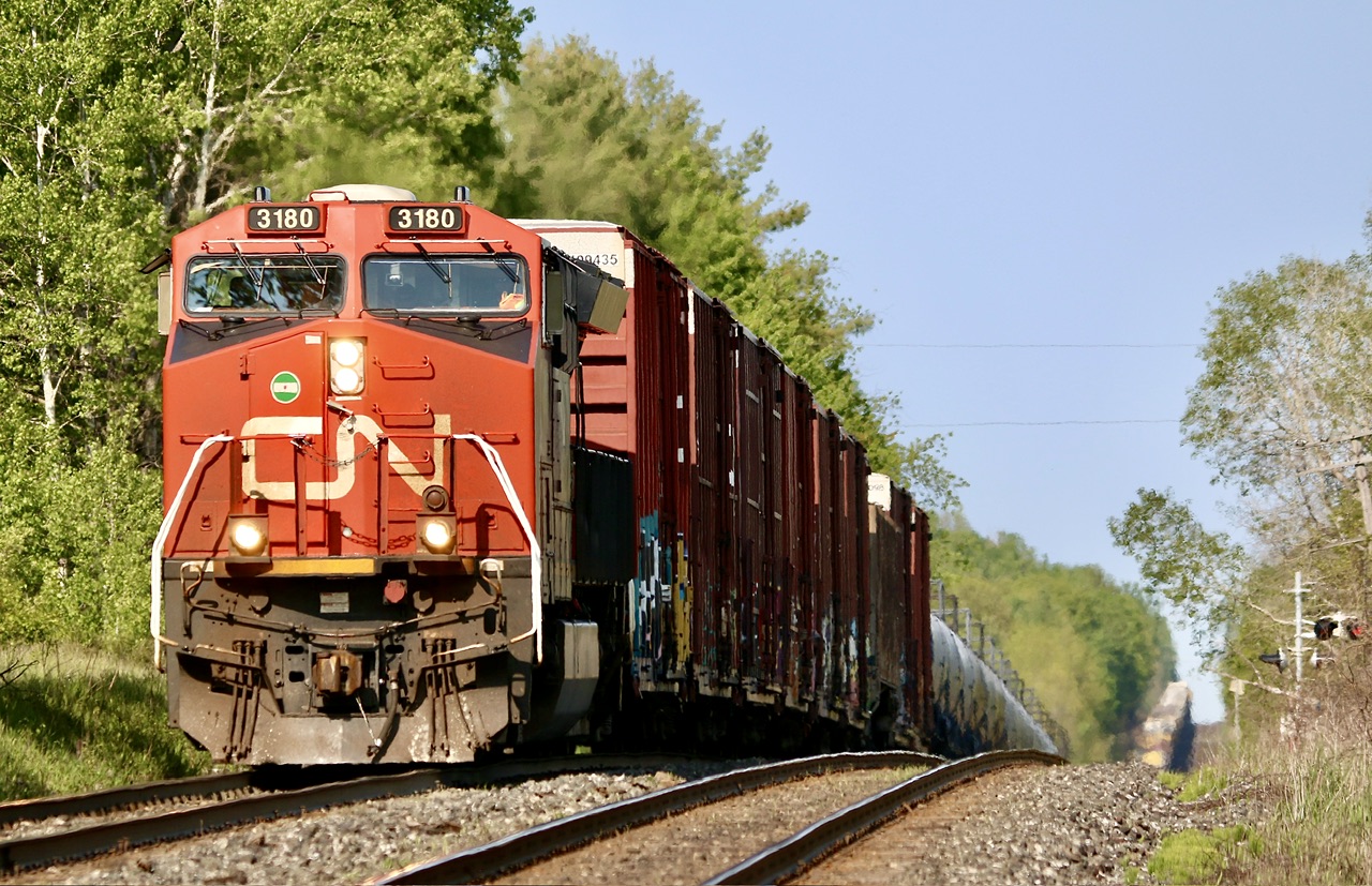 Certainly not the Kingston subdivision I started off Railfaning years ago. For the most part, gone is the variety of motive power, especially all on the head end. This is the land of DPU now and it seems to work well for CN. While I always considered the Kingston subdivision flat, that’s not really the case. The town of Salem is little more than a dot on the map east of Colbourne and I didn’t know it existed until my brother-in-law moved there.   Most visits end up with a brief period of time track side. It was sad to see that CN removed the old closed steel bridge east of town this spring eliminating one of our favourite spots. The shot just west of the bridge quickly illustrates the roller coaster profile that some sections of the subdivision has. Here a westbound comes out of the dip with its ex CREX DPU showing in the distance.