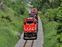 After finishing their drop in Acton and waiting for the passing westbound GO, CN 4705 with CN 7068 fly under the Jones Baseline overpass on their way back to the Guelph Yard. The GP38 was making terrific time with the 3 car load. This location is tough as well with traffic right on your heels and a large Bell telephone line running through the air at picture height.