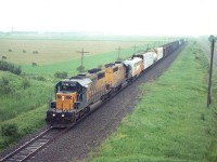 What a grubby looking day.  Sometimes that is the way it goes when you are away from home and the weather forecast does not pan out as promised. I'm on the Hwy 11 overpass at Earlton looking north, as ONR train with  1730, 1736 and 2002 heads to North Bay from Englehart. I rather thought the F unit 2002 was going to perhaps the North Bay shop for some work as I rarely see these units "going along for the ride" since this is a short train. The 2002 was not retired until 2004. Leader 1730 is still on the roster. 

I always found it remarkable to see such fertile flat farmland this far north.

Image shot with Kodak 1000 ISO film. My first crack at it and I found it too grainy for me. Often wondered if it was widely accepted.