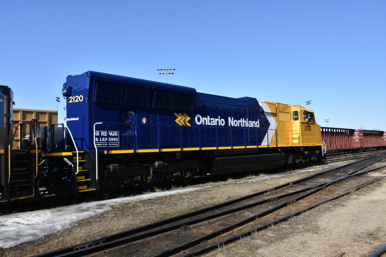 'Repair & Leasing' 
'Power To Keep You Moving' 
Fresh out of the shop from repair and repaint, ONT 2120 soaks up the morning sun on a beautiful mid-April 2023 morning in the ONR yard at North Bay, ON. 
This is the first time I have seen that slogan stenciled at the trailing end of the long hood.