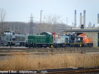 A motly crue (crew) of locomotives found at the CN Sarnia Roundhouse, the building leased to Lambton Diesel. We'll never see this group of locomotives together again as they're all out on assignments now. From left to right: In primer is GMD-1 JLCX 1201 (nee SRY 1201) which would be painted for CREWS for Johnstown Ontario and shipped off in a couple months - this locomotive was not owned by LDS merely serviced and painted by them. In green is SW900 LDSX 904 painted for Roslin Enterprises and now assigned to St. Marys Ontario. Former Esso/CN SW900 now LDSX 7920 is now in GIO Grey and assigned to Welland, seen here being prepared for paint. Former CN SW1200RM now LDSX 7316, pictured in LDS Black, was painted in that black scheme in October 2021. It only lasted in that paint scheme for 3-4 months. Within weeks they'd have it stripped to primer again and painted for a new customer, Nova Industries. In orange is SW1200 former Conrail, HBIX now LDSX 9359 (H. Brorer Equipment, a trackmobile dealer in Aylmer Ontario that owned one locomotive). The locomotive was sold to LDS after being stored at SOR/CN Hamilton then OSR briefly, and is pictured being prepared for NOVA paint. Both 9359 and 7316 are now assigned in shiny nova paint to Nova's new $2 billion Rokeby plant which is just beginning commissioning now. Rokeby is adjacent to the sprawling pre-existing Nova Corunna and shares a track and yard. 