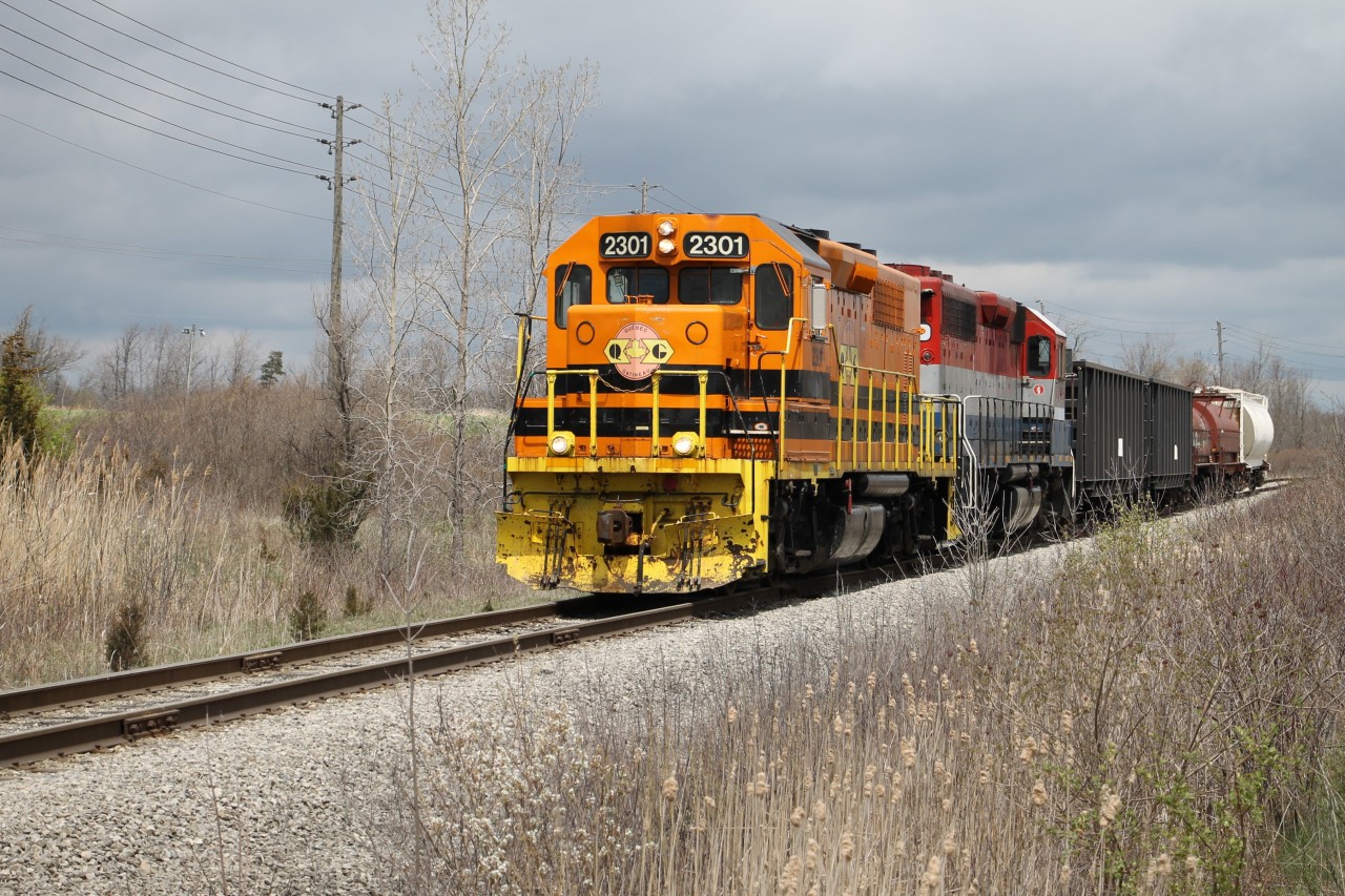With only a few cars trailing today QGRY 2301 and RLK 4095 are heading west at Mile 2.1 on the Stelco Spur about to cross Haldimand Road 3 preparing to stop at the gate to Stelco - Lake Erie Works.