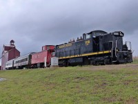 The locomotive is APXX 1118(GMD1) formerly CN 1118(GMD1) built in 1958 and currently in use by Alberta Prairie Rail Excursions. The caboose is APXX 79146. In the background is the former P&H grain elevator that was built in 1920 and closed in 2003. Currently it is a museum run by the Stettler P&H Elevator Preservation Society.