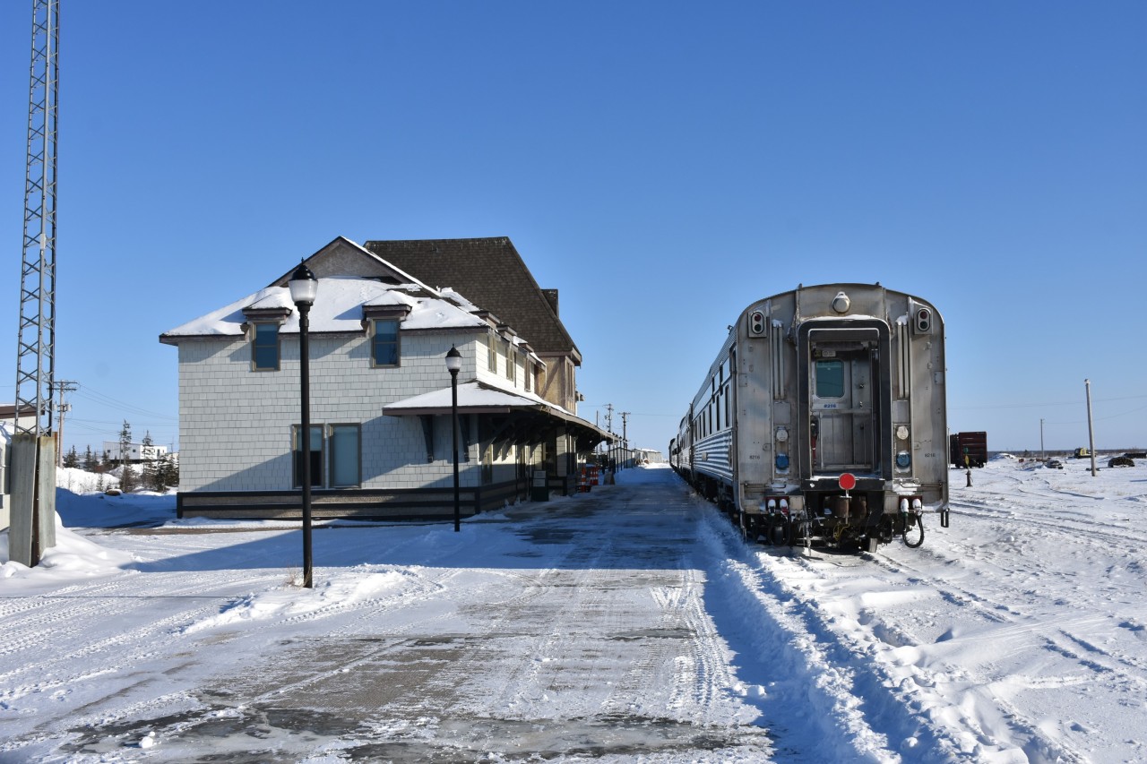 Here's a nice 'cool' scene for this warm May 27, 2023 day we are experiencing in southern Ontario today. 
Having arrived as VIA 693 earlier in the day, the consist for what will become VIA 690 from Churchill to The Pas, MB rests in front of the stately VIA Rail station in late afternoon on this frigid March 14 afternoon. 
Since I was last there in August 0f 2022, a high load has knocked the 'Churchill' station name sign off the north end of the building. 
While it is a nice, sunny, blue sky afternoon, the photo doesn't reveal the bone-chilling outside temperature of -23C feeling -32C.