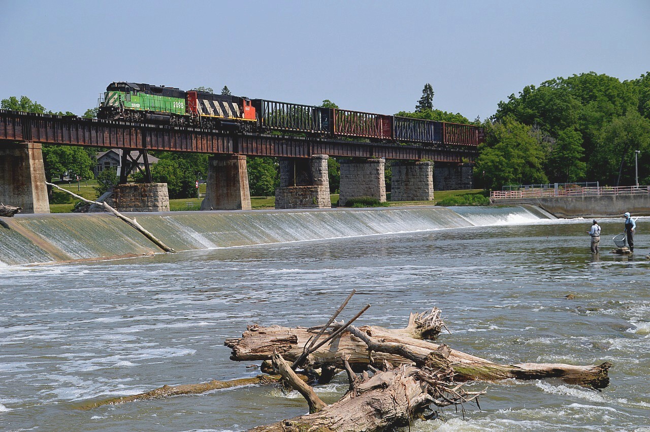 Well, it has been 5 days since the swarming horde of photographers, which I think must have outnumbered the mosquitos, descended upon the little town of Caledonia in order to catch that green BNSF on its run along the Hagersville sub. It almost appears everyone is waiting for someone else to post a photo to Railpictures. So I guess I will do the honours. For those who did not get to witness the action, here is BNSF 2098 and CN 9547 heading south over the Grand River bridge with a few empties to exchange for loads at the CGC (Gypsum plant) at 3rd Line. The train did not continue on to Hagersville, but this day rather just worked CGC and returned to Brantford, with 9547 in the lead.  The whole line is 10 MPH which makes for an easy chase.  CN #580 travels the line here on Mon-Wed-Fri, after 9 AM and before Noon.
