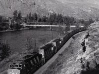 West of Walhachin, CN runs on the north bank of the Thompson River, and at 0635 PDT on Sunday 1980-06-08, in a view essentially just turned around from last week’s post, symbol 218 made its way eastward with month-old 5344 leading 5277 and 5284, with the aged road bridge in the background connecting Walhachin to the Trans Canada Highway.