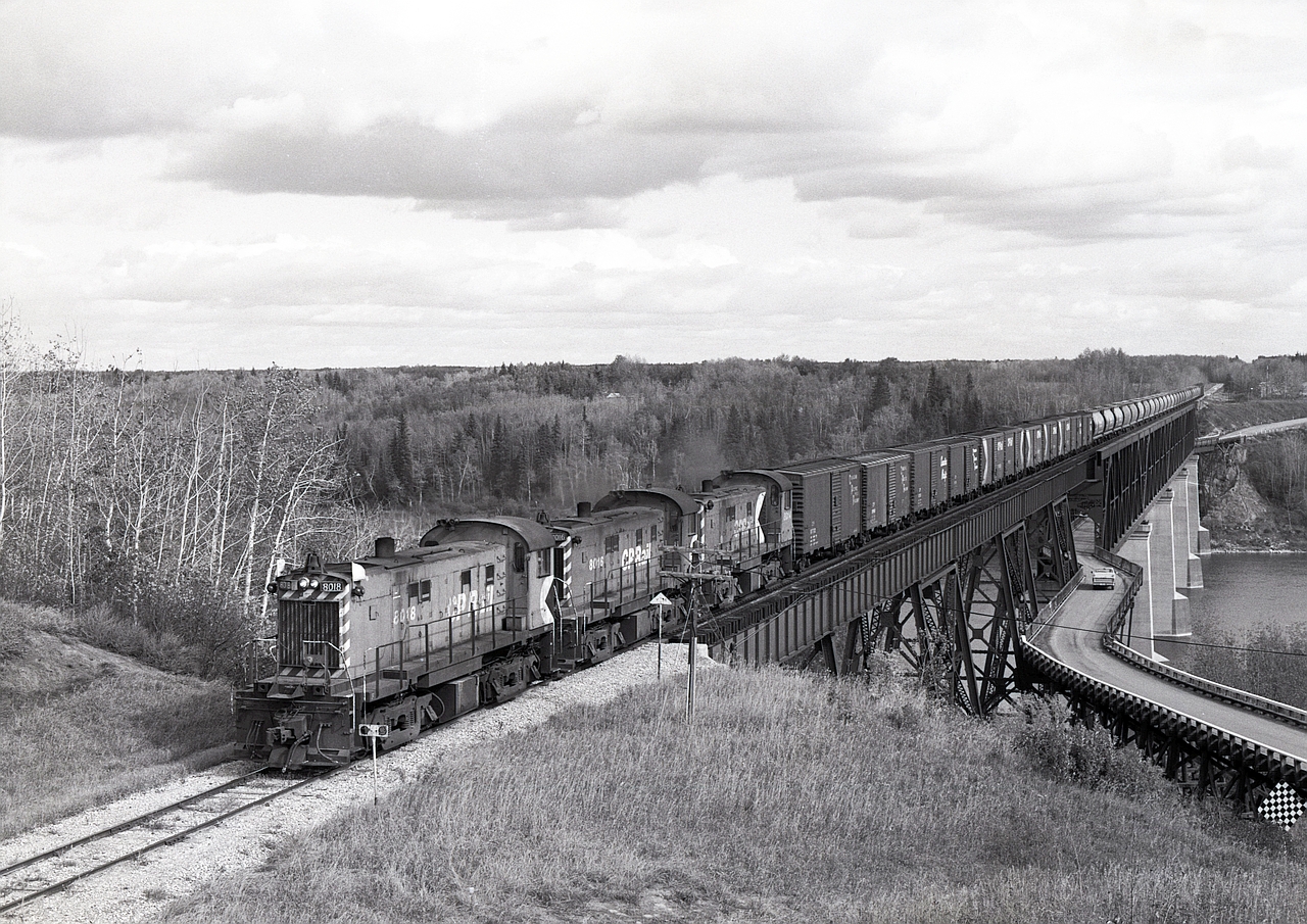 CP used to service its White Fox subdivision with a crew and typically three lightweight RS-23s from Prince Albert, heading north on CN running rights for 18 miles to a junction at Sharpe, then east on CP rails picking up grain loads from elevators.  After exchanging loads for empties and wyeing the units at Nipawin at mile zero, westward they went, peddling empties at elevators through to Meath Park, then cab hop to Sharpe at mileage 73.4 and south on CN back to Prince Albert.

Seen on Wednesday 1981-09-23 at 1353 CST, CP 8018 + 8016 + 8014 are wheeling the empties across the Saskatchewan River (71 km as a crow flies downstream of the confluence of North and South branches) bridge at mileage 1.6 just west of Nipawin, a crossing then shared with old highway 37 on a lower deck, but now closed to road traffic.  The railway there is now Torch River Rail, and extends westward only to mileage 27.2 at Choiceland.
