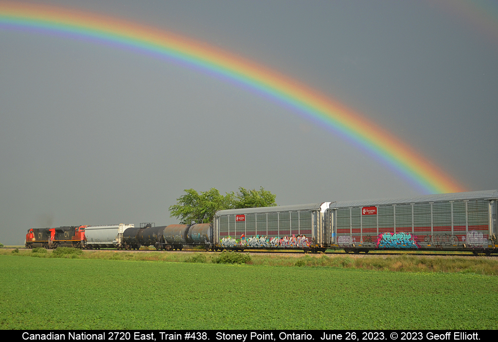 Somewhere 'under' the rainbow.  CN (IC) 2720 leads train #438 eastbound as it nears Stoney Point, Ontario on June 26, 2023.  With on/off rain most of the day we were seeing open skies inbetween the showers.  As luck would have it I happened to hear 438 approaching Belle River and was able to get far enough ahead of the train to get a nice going away shot with one of the most brilliant rainbows I think I have ever seen included.  I've always said, "I'd rather be lucky than good"....  :-)