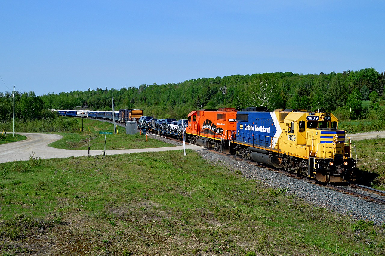 Beautiful sunny morning. We are standing on a mound at mile 5 out of Cochrane. The Polar Bear Express (PBX) was running a bit late on account one of the boxcars had a temperamental door that didn't want to close just before the 0900 departure. In the meantime, the endless flies invited us to be their dinner and the train could not come soon enough. Consist was impressive.......ONR 1809, 1808 (Every Child Matters) some freight up front and three more boxcars on the rear with auxiliary power unit #202 and seven coaches in between. Gotta love the ONR.