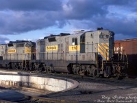 Bellequip GP7 110 and GP9 130 sit dodging the shadows by the diesel shop turntable inside Canadian Pacific's Toronto (Agincourt) Yard. At the time, both units were part of a large group of former Quebec, North Shore & Labrador (QNS&L) GP7/GP9 units that were leased by CP in the early-mid 1970's, initially through a group called "Bellequip" (apparently run by some CP management types on the side). They later sold their lease fleet to Us-based Precision National Corp (with all units later relettered PNC by CP). By the mid-1970's traffic lull, the old Geeps all came off-lease, and most ended up purchased by the Chicago & North Western.
<br><br>
Apparently QNS&L embarked on a rebuild/upgrade program for their GP7's at one time, so 110 is now a GP9 equivalent (larger main generator retrofit? note the extra louvres/vents on the hood doors. Information on this program is hard to find).
<br><br>
<i>Ray Sabo photo, Dan Dell'Unto collection slide.</i>