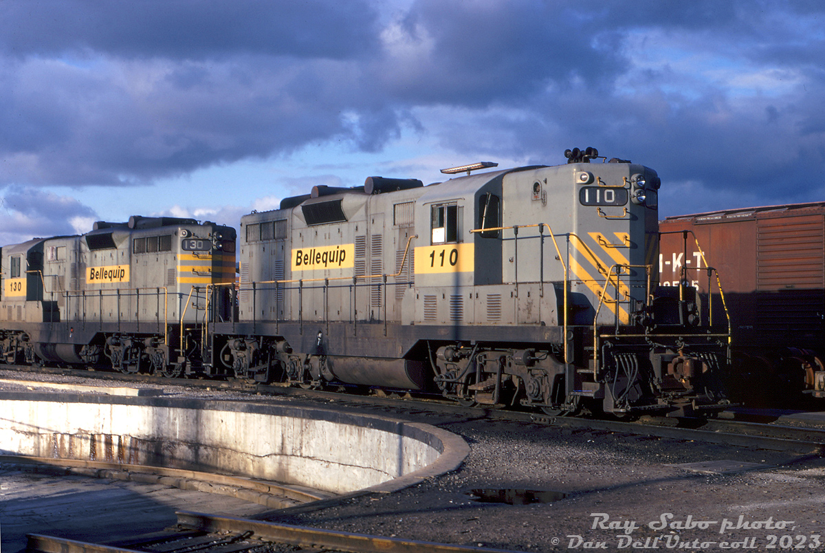 Bellequip GP7 110 and GP9 130 sit dodging the shadows by the diesel shop turntable inside Canadian Pacific's Toronto (Agincourt) Yard. At the time, both units were part of a large group of former Quebec, North Shore & Labrador (QNS&L) GP7/GP9 units that were leased by CP in the early-mid 1970's, initially through a group called "Bellequip" (apparently run by some CP management types on the side). They later sold their lease fleet to Us-based Precision National Corp (with all units later relettered PNC by CP). By the mid-1970's traffic lull, the old Geeps all came off-lease, and most ended up purchased by the Chicago & North Western.

Apparently QNS&L embarked on a rebuild/upgrade program for their GP7's at one time, so 110 is now a GP9 equivalent (larger main generator retrofit? note the extra louvres/vents on the hood doors. Information on this program is hard to find).

Ray Sabo photo, Dan Dell'Unto collection slide.
