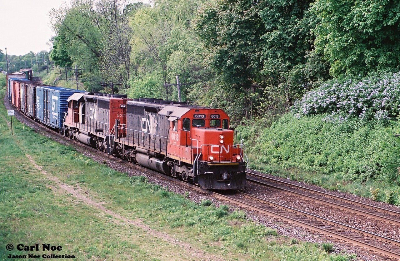 A CN eastbound with SD40u 6013 and SD40-2 5379 is viewed curving through the town of Paris approaching the John Avenue overpass as it heads to Hamilton on the CN Dundas Subdivision.