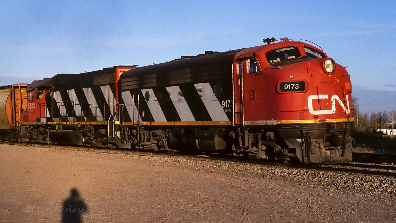Only a moderate train of hoppers keeps these 2 units working, but not hard, up the hill from the river. I am almost at the same spot as my last photo, on the other side of the tracks this time with the sun in the west sky. By this date, flags were no longer used, sometimes the class lights would be lit. On the happy side, all the doors are closed.
