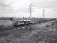 I suppose a dull overcast day is not the right choice for going out experimenting with B/W roll film in a 2x3 roll holder on the back of a 4x5 Speed Graphic, but out I went anyway. Oh the challenge of the film days. Kinda miss them.
I'm up on the side of the QEW overpass in Burlington, looking east. Barely visible in the extreme right is the Burlington West station.
CN 9545, 9310 and 9305 is the power for this train just coming off the Halton sub, welded rail cars ahead of general freight by the look of it.  At least it wasn't raining.......