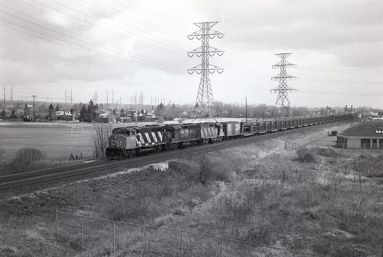 I suppose a dull overcast day is not the right choice for going out experimenting with B/W roll film in a 2x3 roll holder on the back of a 4x5 Speed Graphic, but out I went anyway. Oh the challenge of the film days. Kinda miss them.
I'm up on the side of the QEW overpass in Burlington, looking east. Barely visible in the extreme right is the Burlington West station.
CN 9545, 9310 and 9305 is the power for this train just coming off the Halton sub, welded rail cars ahead of general freight by the look of it.  At least it wasn't raining.......