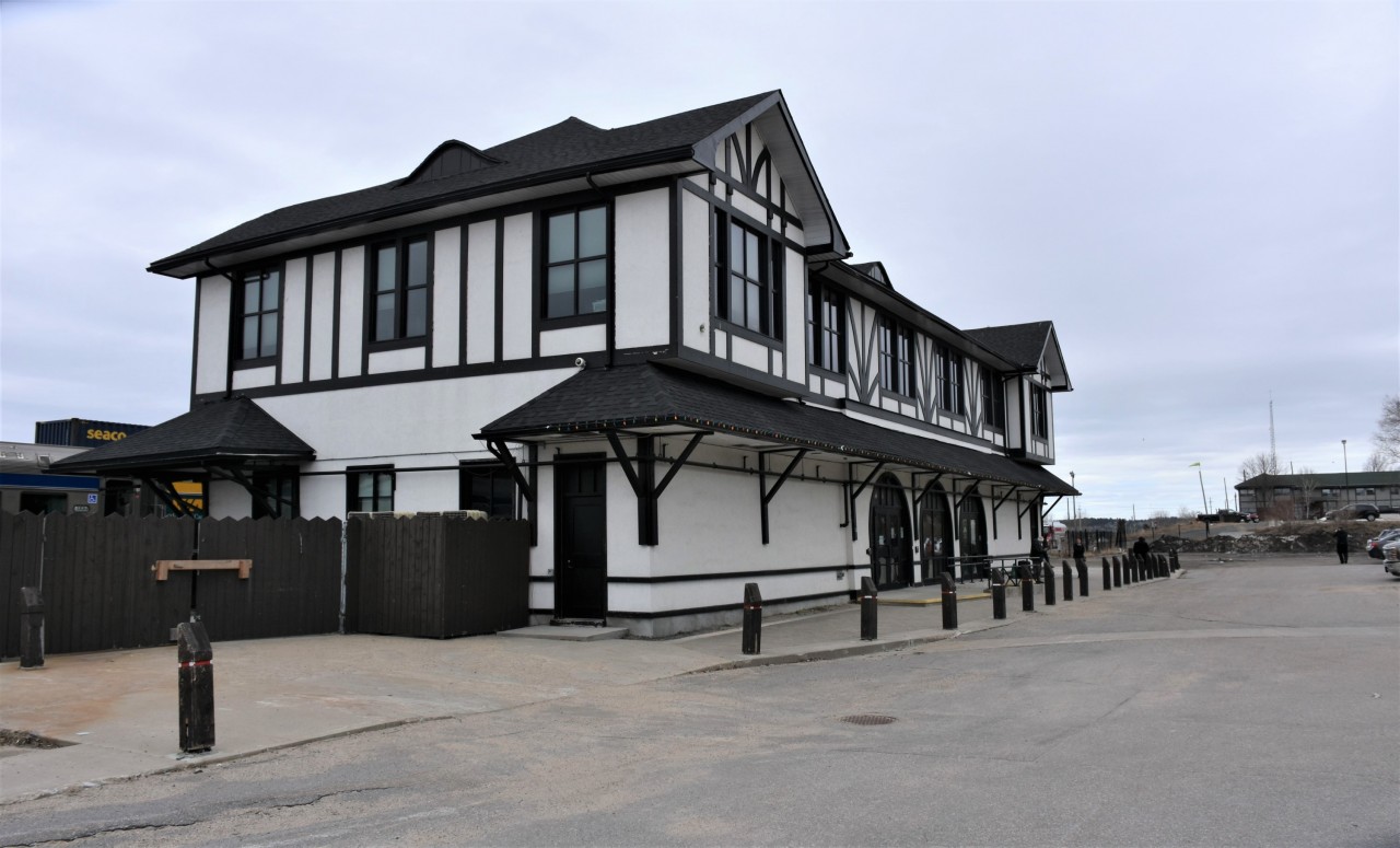 Here's a street side view looking west of the impressive Sioux Lookout, ON station, with VIA 001 The Canadian stretched out along the platform on CN's Allanwater and Redditt Sub. mainline track.
With a headend crew change and refueling taking place here, the front of the train is only a few passenger cars past the west end of the station leaving about 20 car lengths, or more than a 1/4 mile walking distance for folks in Prestige Class to make their way to this location.
It was a cool, overcast, but pleasant mid-day arrival in The Sioux and lots of passengers took advantage of the 35-minute stop to detrain and stretch their legs.