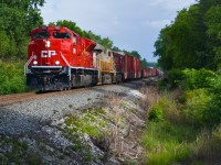 Emerging from a gloomy rain shower to the south, freshly washed EMD SD70ACU 7052 catches the evening sun as it leads CP train 421 north to Baxter, where it will meet a ballast train. CP's fleet of SD70ACUs look sharp in the newest rendition of the famed Candy Apple Red colours, with the recently revived golden beaver herald on the long hood.