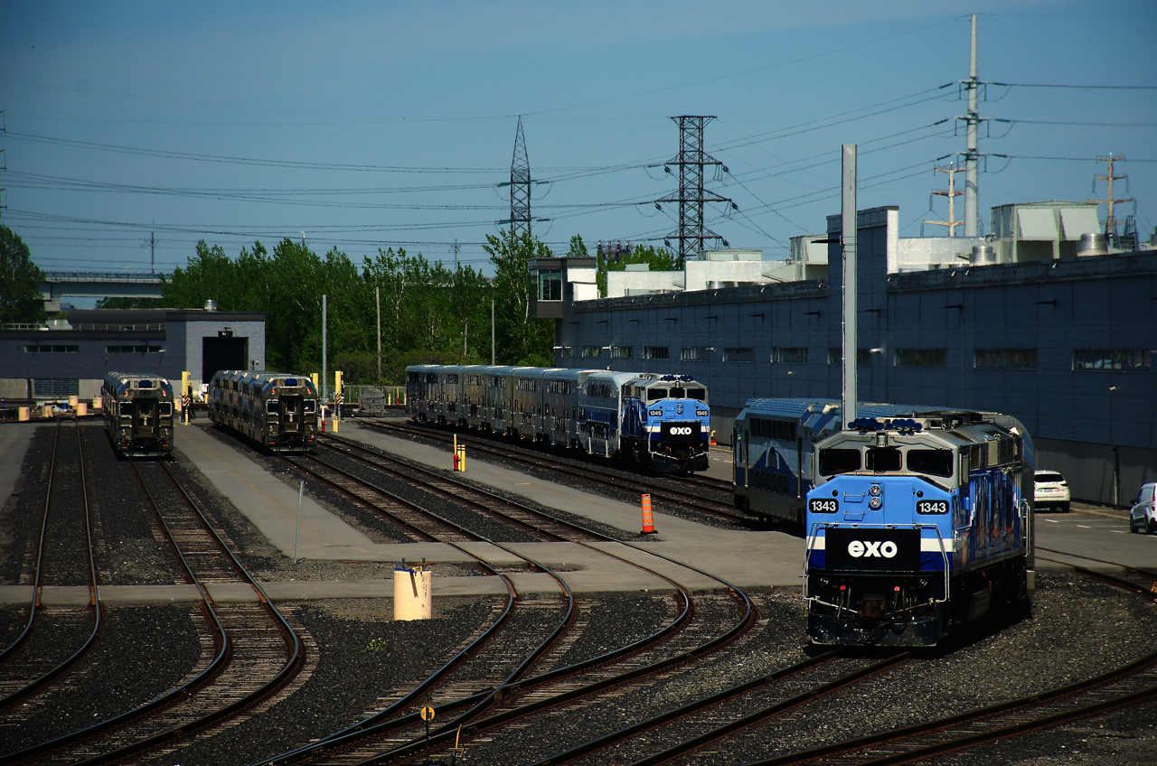 EXO 1209 is leaving EXO Pointe-Saint-Charles Maintenance Centre, on its way to Central Station for the evening rush hour. At far left are two consists for the Mont St-Hilaire line and further to the right is EXO 1345 with a single Bombardier bilevel, followed by CRRC bilevels.
