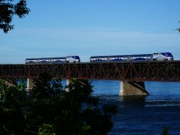 Deadhead and revenue moves are meeting over the St. Lawrence River during the morning rush hour. At left EXO 1328 leads EXO 76 towards the island of Montreal, while EXO 1320 at right pushes EXO H73 towards the South Shore. It will provide the consist for EXO 80, the 0825 departure from Candiac for Montreal.
