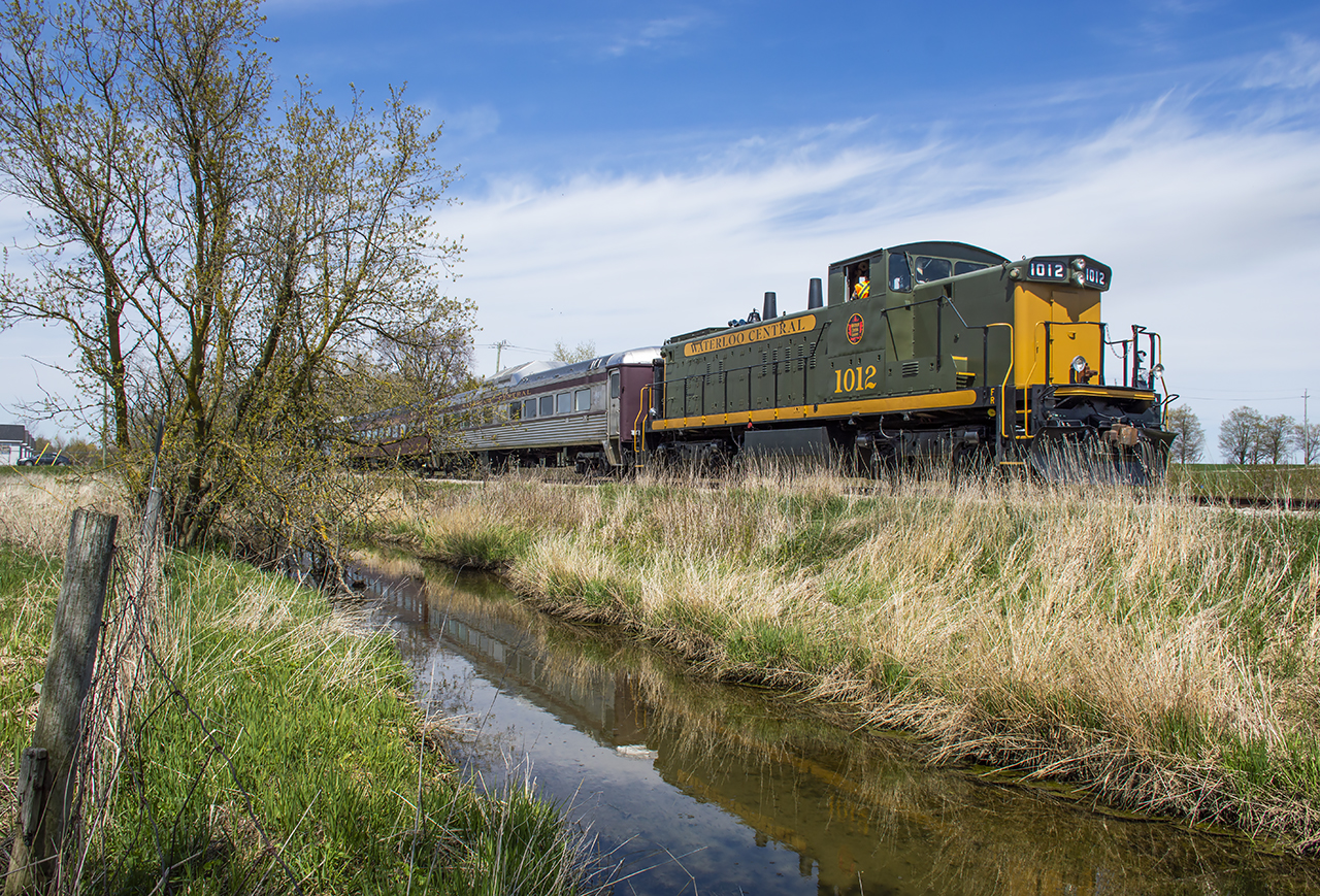 Approaching the town of Elmira, Waterloo Central's GMD-1 1012 shoves its short passenger train through the farm fields of Woolwich Township.  Shortly they will return south to the St. Jacob's Market before returning to the shop at St. Jacob's.
