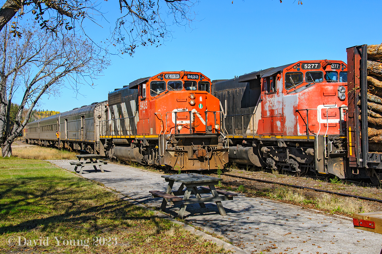 It's train time at Hawk. The southbound "Tour of the Line" passenger train arrives, guided by a crew member who is standing in the front vestibule of the lead coach. Sitting in the next track over in the yard is northbound freight 571 awaiting their freight crew to come on duty with the solo SD40-2W 5277. The final "Tour of the Line" operated in 2015- which at that time was ran by Railmark crews. During 2021, Watco would put in an offer to purchase the line  from Sault Ste. Marie to Oba (as well as various other branches in the Upper Peninsula of Michigan) and  as of February 1, 2022 would commenced operations as the "Agawa Canyon Railroad". They currently switch freight mostly in the Sault Ste Marie area and operate the Agawa Canyon Tour train in the fall. But the tracks from Canyon thru Hawk and up to Oba have, as far as I know remained silent ever since. There was hope the passenger would start up again... time will only tell.