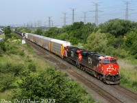 Not a bad late morning for CN action near MacMillan Yard: CN ES44AC 3902 and AC44C6M (rebuilt C44-9W) 3323 lead an eastbound freight over the Humber River bridge, about to duck under the underpass at Weston Road. An westbound intermodal for Brampton Intermodal Terminal would soon pass by once the Humber was clear, followed by another eastbound freight yarding into MacMillan Yard, and an eastbound intermodal departing out of BIT.<br><br>Quite a nice change from just a few days earlier, when the wildfire smoke and smog blanketing Ontario made this spot almost intolerable on a hot sunny afternoon.