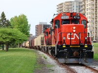 CN GP38-2s 4719 and 7502 walk through Sarnia's downtown Centennial Park with a baker's dozen cars of fertilzer for the Cargill agricultural facility at Sarnia's downtown harbour.
