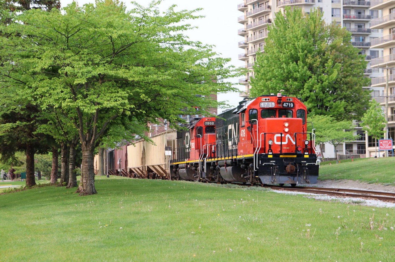 GP38-2s 4719 and 7502 push a string of covered hoppers through Sarnia's downtown Centennial Park to the Cargill elevator facility at Sarnia Harbour on a rare Sunday evening run on the Point Edward Spur.