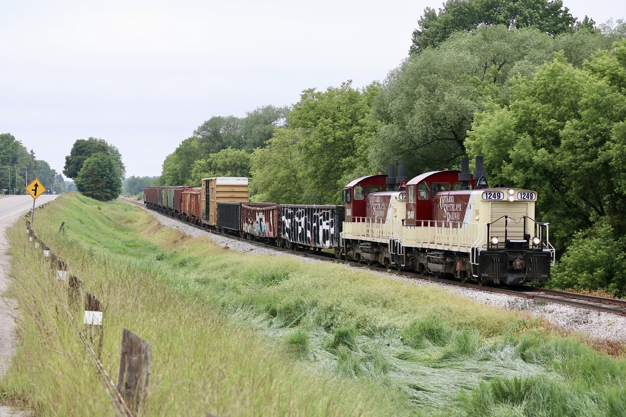 I’ve been lucky enough over the years to photograph pretty much all of OSR’s fleet in action. I had hoped to catch the matching OSR painted SW1200’s together but figured it was going to be a hard task as I don’t make it out this way as often anymore, not to mention OSR is a bit more conservative now with the power it assigns to daily assignments. Thankfully the dreary weather this day didn’t stop us from making the trip to Ingersol even though we had no idea what power would be in charge of the days runs. After seeing these two “pups” sitting at the Cami plant, I assumed they would spend all day working the auto racks there. Thankfully after a trip a bit later to the CN interchange, the pair headed to Woodstock with a mixed train. They really do look good in corporate colours. Here the pair are digging into the slight grade with their relatively short train.
