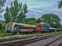 On June 13, 2023, VIA 37 (Quebec - Ottawa) has just left Central Station and entered the Montreal Subdivision. The train meets CN 596, the Pointe-Saint-Charles switcher, working a new gondola train.