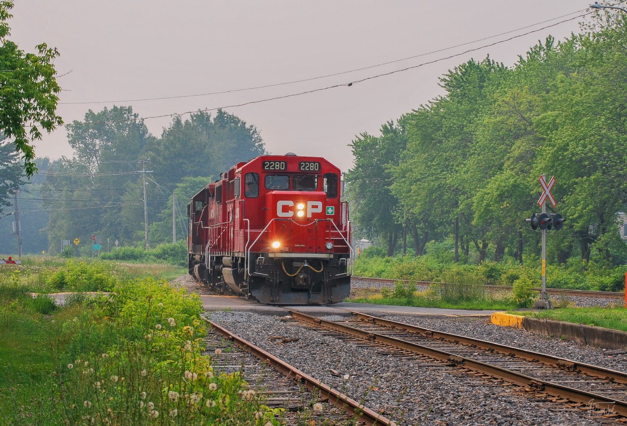 On June 25, 2023, CPKC G20 has just deposited the rest of its train on the siding just north of Farnham Yard, where the cars will be picked up by CPKC 121 in the evening. The light power now returns to Sherbrooke where the crew will have finished their day.