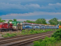 On June 26, 2023, CPKC 119 awaits its signal on the ramps of Dorval. The EXO 26 to destination 26 crosses it and it will then be the CPKC to pass.