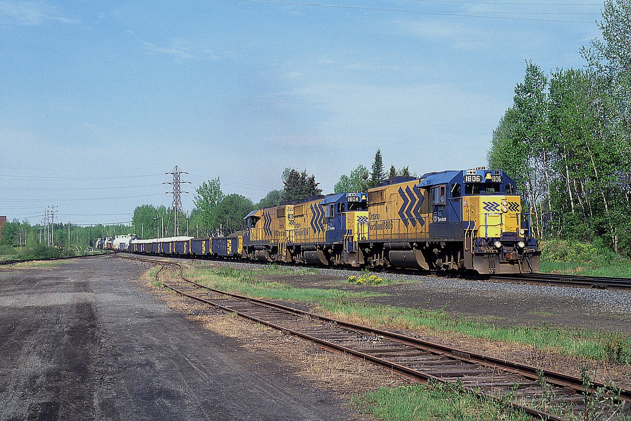 A trio of GP 38-2 locomotives handles the traffic for Rouyn-Noranda on a nice sunny morning. The train is passing thru Kirkland Lake roughly where the station used to be. These units, along with SD40-2s  used to be the standard power before the railroad got into the SD75I locomotives in mid-1999. Power on this train is 1906, 1804 and 1802.
