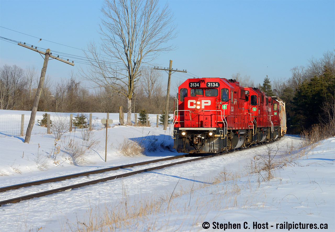 On a beautiful Kodachrome blue sky winter's day, Canadian Pacific Railway's T72 is nearly done for the day as they blast around the final curve in Ayr before entering Wolverton Yard with a tripleset of GP38-2's. Note the insulator that just wouldn't hang on any longer on the codeline.