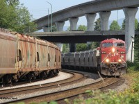 An eastbound potash train led by CP 8735 rounds the bend at Sperling in Burnaby, BC, passing a westbound potash train with CN power waiting to take the tunnel to North Vancouver. Immediately after the front end of the eastbound passed me, another westbound went through the middle track, occupying all three tracks. That train had sulphur loads with CN power. It was a hot few minutes after an almost 1.5 hour lull with only the waiting westbound potash train. June 23, 2023. 