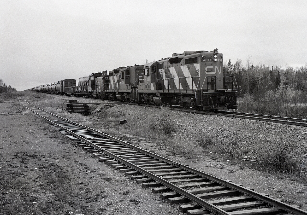 Right on the border between Alberta and Northwest Territories at mileage 300.4 on the Meander River sub. of CN’s Great Slave Lake division, northward symbol train 875 on Saturday 1978-09-23 had two GP9s and an SW1200RS, CN 4341 + 4351 + 1376, for power as it crossed latitude 60 degrees north at 1141 MDT.  Last station was Indian Cabins, AB, at mileage 291.3, next is Grumbler, NWT, at 311.3