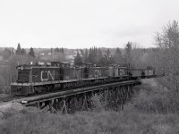 On Wednesday 1980-09-24 at 1554 MDT, a CN northward Athabasca Turn with a trio of GMD-1s 1009 + 1007 + 1008 is crossing the Tawatinaw River bridge at mileage 92.8 of the Athabasca sub. and about to cross highway 55 and enter downtown Athabasca on the south bank of the river of the same name.  This was the northernmost reach of the Canadian Northern Railway system.

<p>Since 1947, Athabasca sub. trains from Edmonton ran on 20.2 miles of Northern Alberta Railways to reach a junction at Morinville, in preference to the now abandoned original CNoR route northward from Trelle Jct. near St. Albert for 12.1 miles to a diamond crossing of NAR at Morinville.  CNoR reached Morinville first, in October 1906, and NAR predecessor Edmonton, Dunvegan & British Columbia arrived in December 1912, so the diamond and interlocking were ED&BC then NAR responsibility.