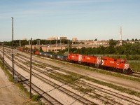 Viewed from the Markham Road overpass above SNS Toronto Yard, CP 5864 + 4246 + 5590 are bringing a westward container train into the yard in Agincourt at 1908 EDT on an extremely warm Wednesday 1994-07-13.