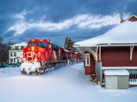 A pair of GEs power CN train 594 as they rumble by the old train station in Hampton, New Brunswick near sunset. The colors of the ponies really stand out. 
