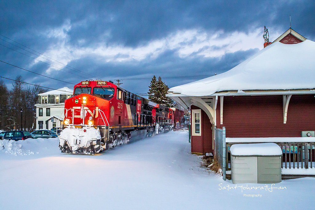 A pair of GEs power CN train 594 as they rumble by the old train station in Hampton, New Brunswick near sunset. The colors of the ponies really stand out.