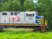 Canada Day 2023. CN 2774 leads train 594 at Passekeag, New Brunswick. Every Canada Day, a buddy of mine, engineer MJR hangs the Canada Flag on the side of his train. This year is the first year I've been able to nab a decent photo of the flag waving in all it's glory, as well as a thumbs up from MJR. 