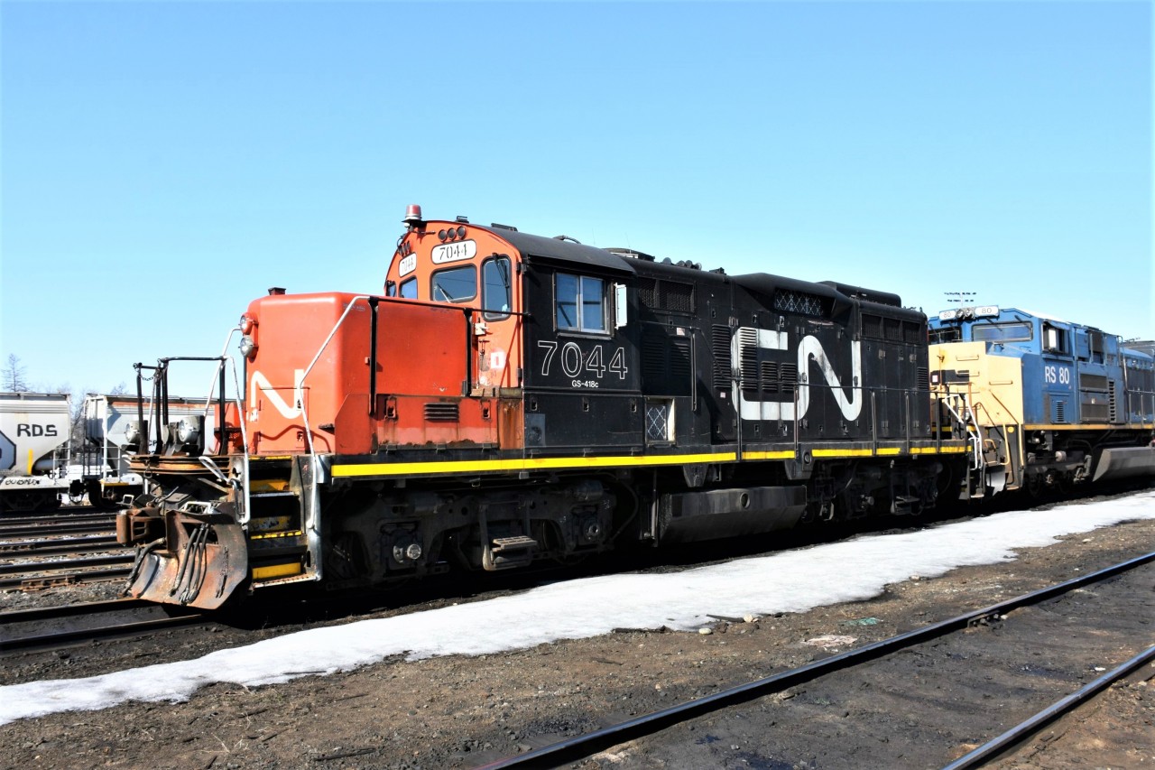 CN 7044 GS-418c EMD GP9RM (ex-CN 4318 GP9) sits in line with other foreign power on a yard track outside the ONR diesel shop in North Bay, ON April 13, 2023.