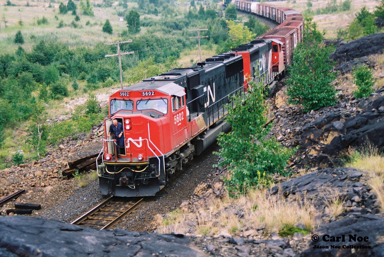 The conductor of CN train 219 with 5602 and 9558 is pictured exiting the cab as his train slowly approaches the diamond with CP’s Cartier Subdivision near Coniston, Ontario. There was nothing in my notes about this one, but he likely had to get out for a reason relating to his Bala Subdivision train crossing the CP line.