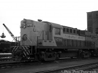 New and only four months old at the time, Canadian Pacific RS18 8796 sits on the shop tracks in Lambton Yard near the steam-era coaling tower with sister unit 8740. At the time CP was purchasing various diesel locomotives from GMD, MLW and CLC as part of its ongoing dieselization efforts to phase out steam by the end of the 1950's. CP, reluctant to buy more MLW roadswitchers due to issues of the previous 244-powered units like the RS10, purchased a 20-unit order of RS18 units in 1957 featuring the new 251 engine (8729-8748, of which 8740 was added to the roster on April 30th 1957) and liked what they saw, so followed up with a 52 unit order the next year in 1958 (8749-8800, of which 8796 was added to the roster on July 9th 1958, as per the Dean & Hanna CPR book). <br><br>Being equipped with standard 75mph gearing (vs EMD's 65mph) and pass-through trainlines, they would be versatile locomotives in both passenger and freight service. Some of the later units like 8796 were delivered with the lightweight AAR-B style trucks without the center spring pack, also found on the smaller RS23 units. These trucks would get swapped around onto various first-generation Alco/MLW road units for years (the practice seemed to end around the mid-70's when CP starting getting rid of their 244-powered units). The RS18's would be rebuilt as 1800-series road units in the 1980's (CP 8740 became 1804, and 8796 became 1836. Despite the yard unit number series, they retained their 75mph maximum speed rating for road service) and would soldier on until the final MLW's were retired in 1998.<br><br><i>Original photographer unknown (possibly a Bill Grandin photo), Dan Dell'Unto collection negative.</i>