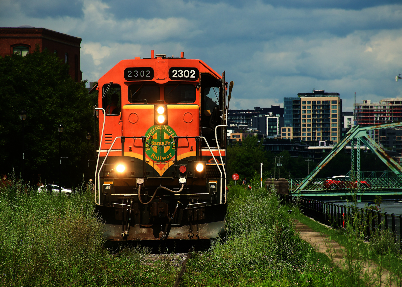 The weeds are high as CN 500 with a BNSF leader shoves grain cars towards Ardent Mills.