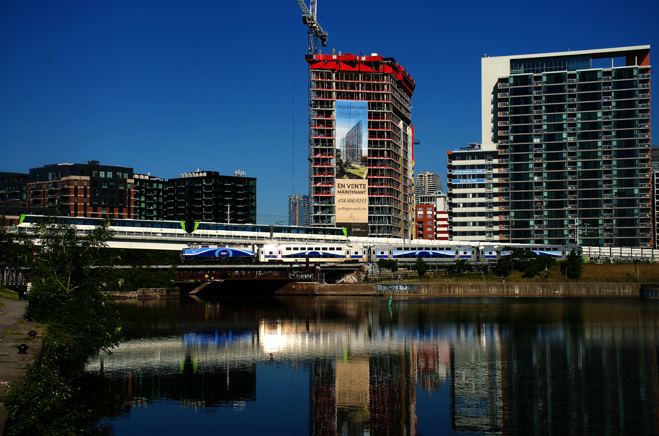 EXO 1343 leads a deadhead move past the Peel Basin as an REM train heads towards Central Station. After months of testing, the light rail system is finally scheduled to open to the public on July 31st.
